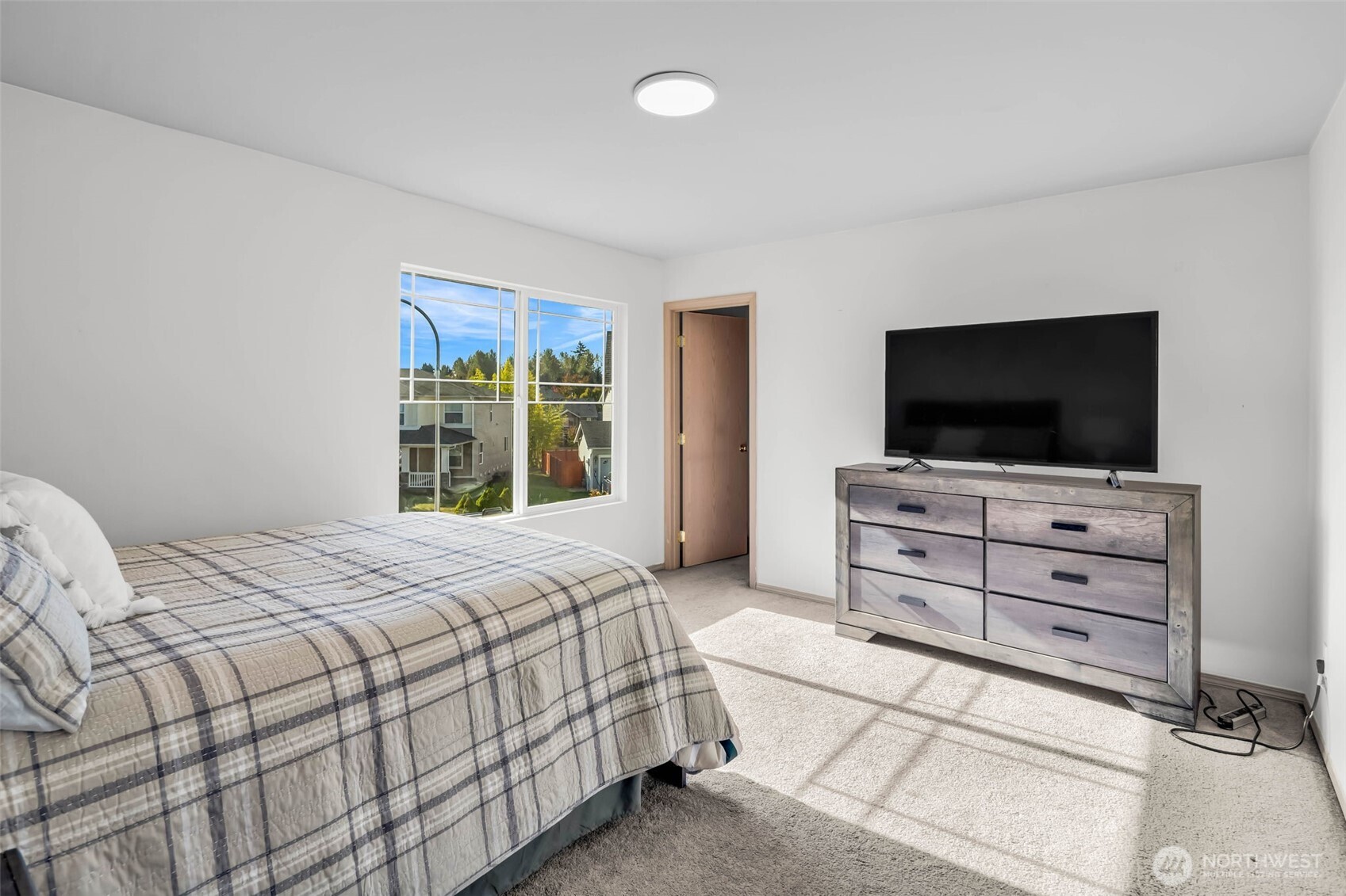 12830 Southeast 299th Street Auburn, WA 98092 - Photo 12 of 30 a bedroom with a bed and a flat tv screen on wall