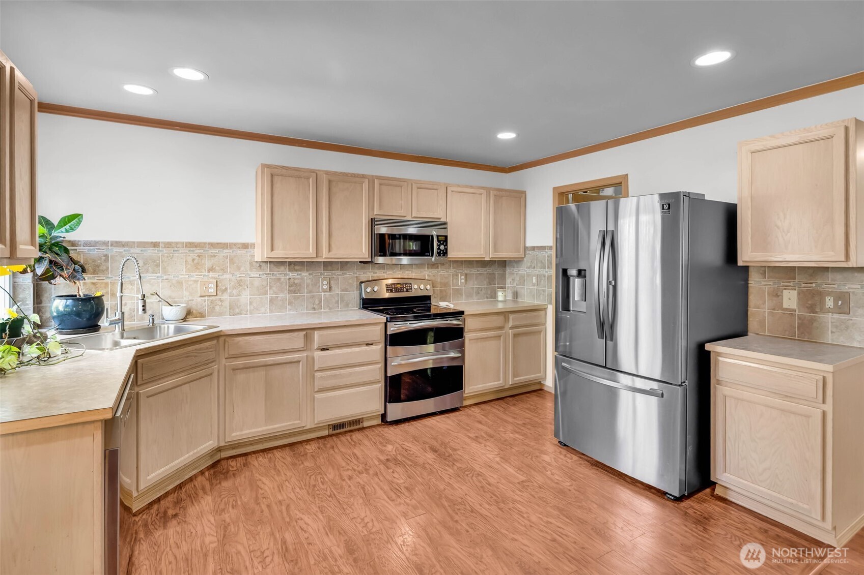 12830 Southeast 299th Street Auburn, WA 98092 - Photo 8 of 30 a kitchen with a refrigerator a stove top oven a sink and dishwasher with wooden floor