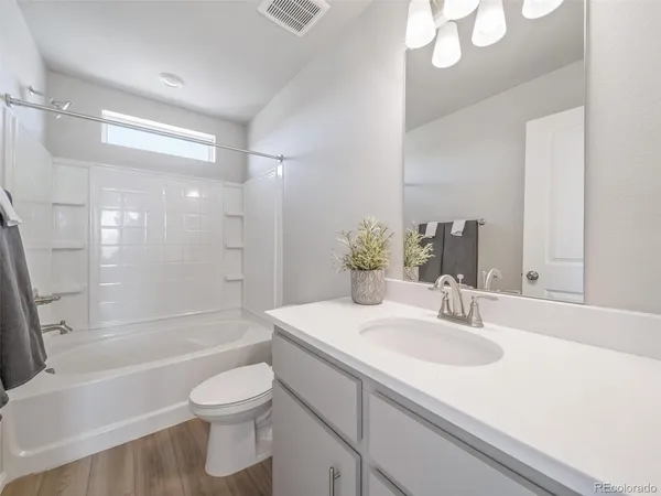a bathroom with a sink a toilet and a large mirror