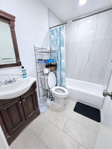a bathroom with a sink a toilet a mirror and shower