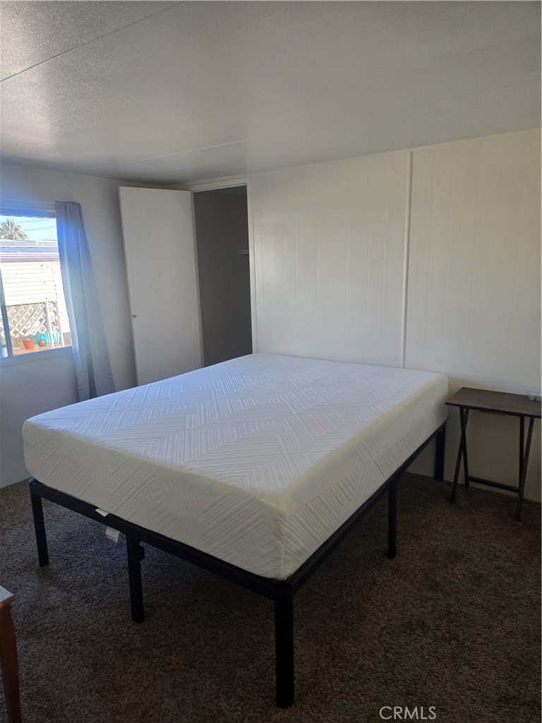 15252 Seneca Road, Unit 7 Victorville, CA 92392 - Photo 17 of 20 a bed sitting in a bedroom next to a window