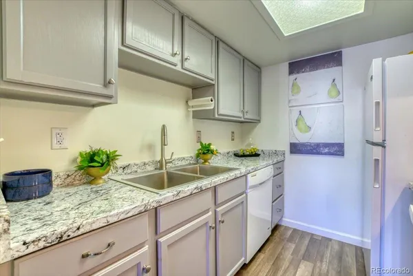 a kitchen with granite countertop a sink stainless steel appliances and cabinets