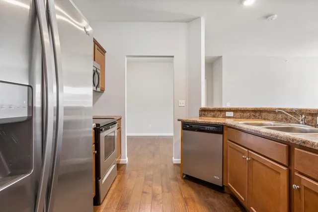 a kitchen with stainless steel appliances granite countertop a refrigerator and a sink