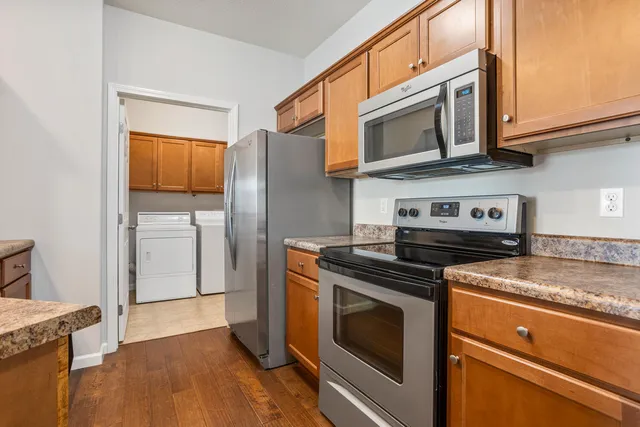a kitchen with stainless steel appliances granite countertop a stove microwave and refrigerator