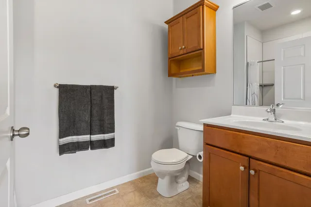 a bathroom with a toilet sink vanity and mirror