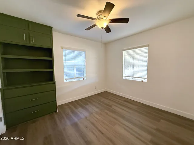 a view of an empty room with a window and a ceiling fan