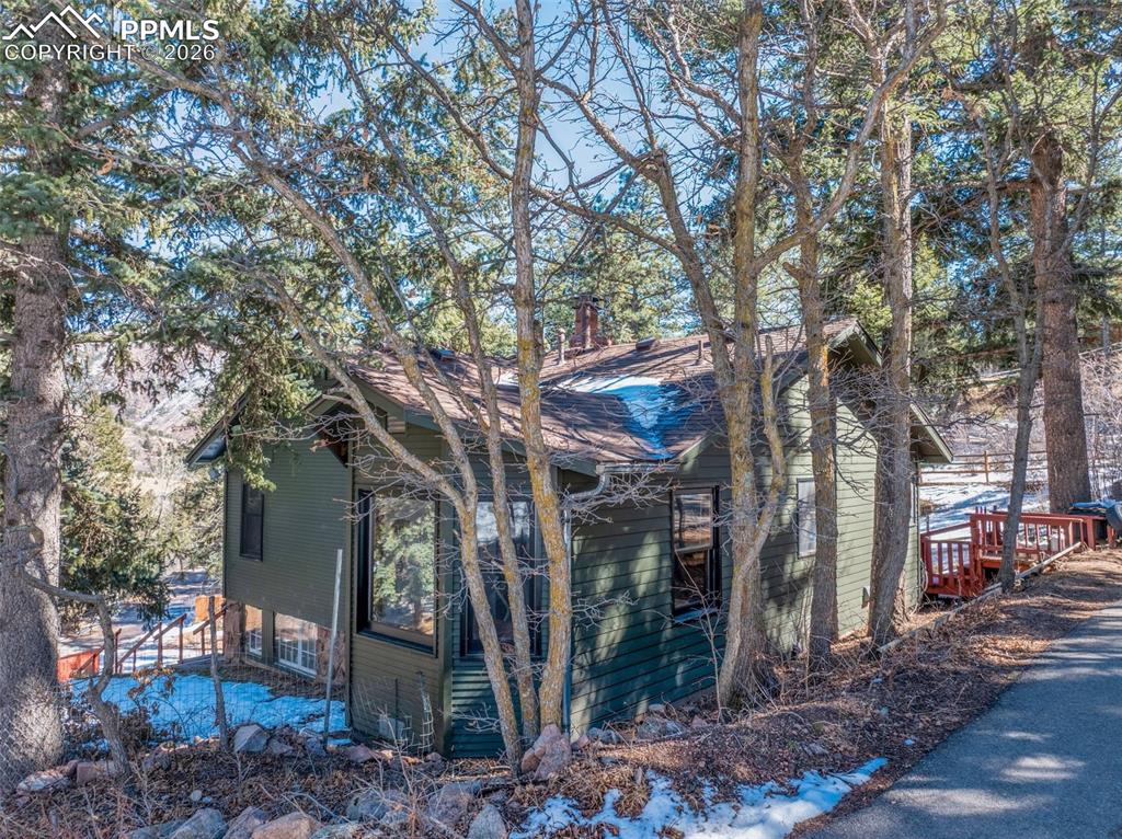 9735 Mountain Road Cascade, CO 80809 - Photo 6 of 44 a view of a wooden house with a yard