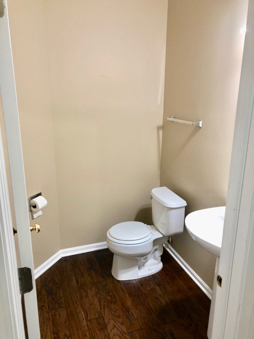 3072 Falling Waters Lane Lindenhurst, IL 60046 - Photo 8 of 27 a white toilet sitting next to a bathroom sink and a vanity
