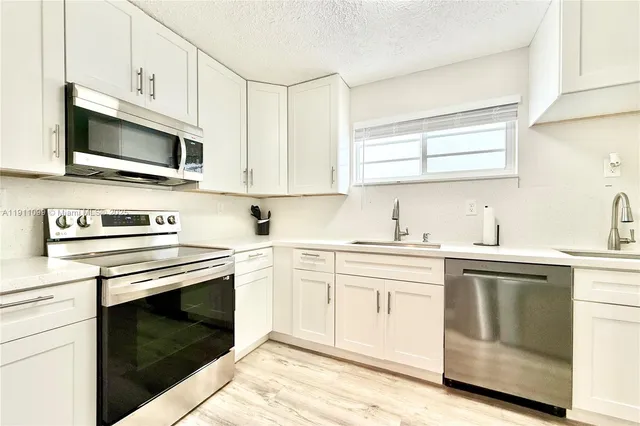 a kitchen with cabinets stainless steel appliances and a sink