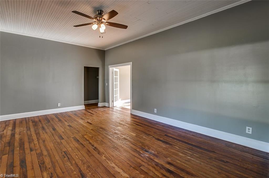 Living room with original hardwood floors. Leads to kitchen/dining room. 