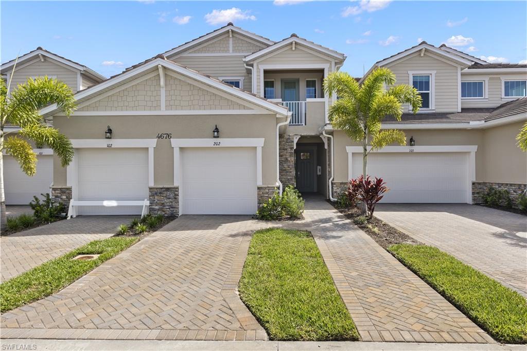 4676 Arboretum Circle, Unit 102 Naples, FL 34112 - Photo 1 of 35 a front view of a house with a yard and potted plants