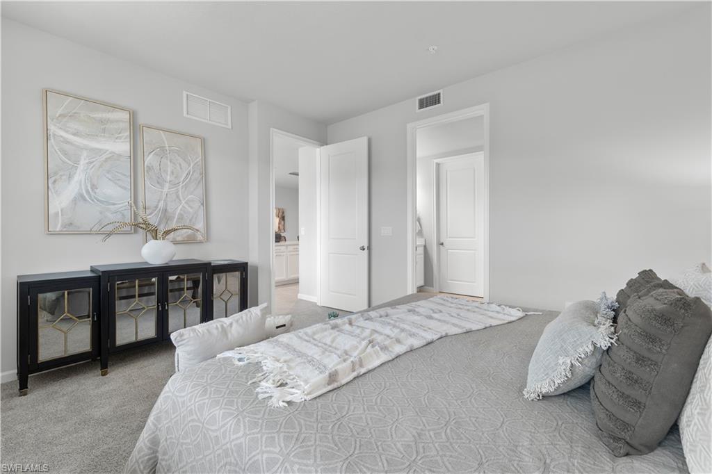 4676 Arboretum Circle, Unit 102 Naples, FL 34112 - Photo 23 of 35 a bedroom with a large bed and dresser