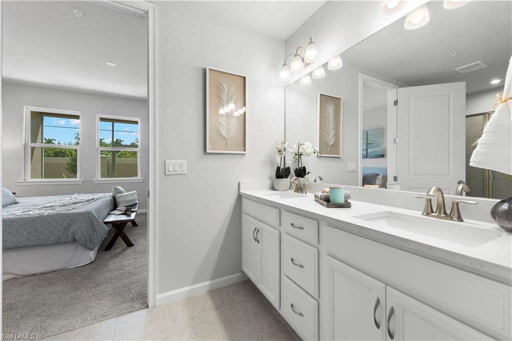 4676 Arboretum Circle, Unit 102 Naples, FL 34112 - Photo 27 of 35 a spacious bathroom with a double vanity sink large mirror and a bathtub