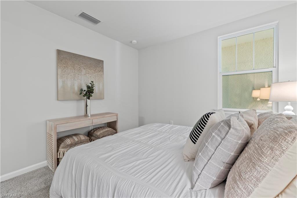 4676 Arboretum Circle, Unit 102 Naples, FL 34112 - Photo 31 of 35 a bedroom with a bed and a night stand