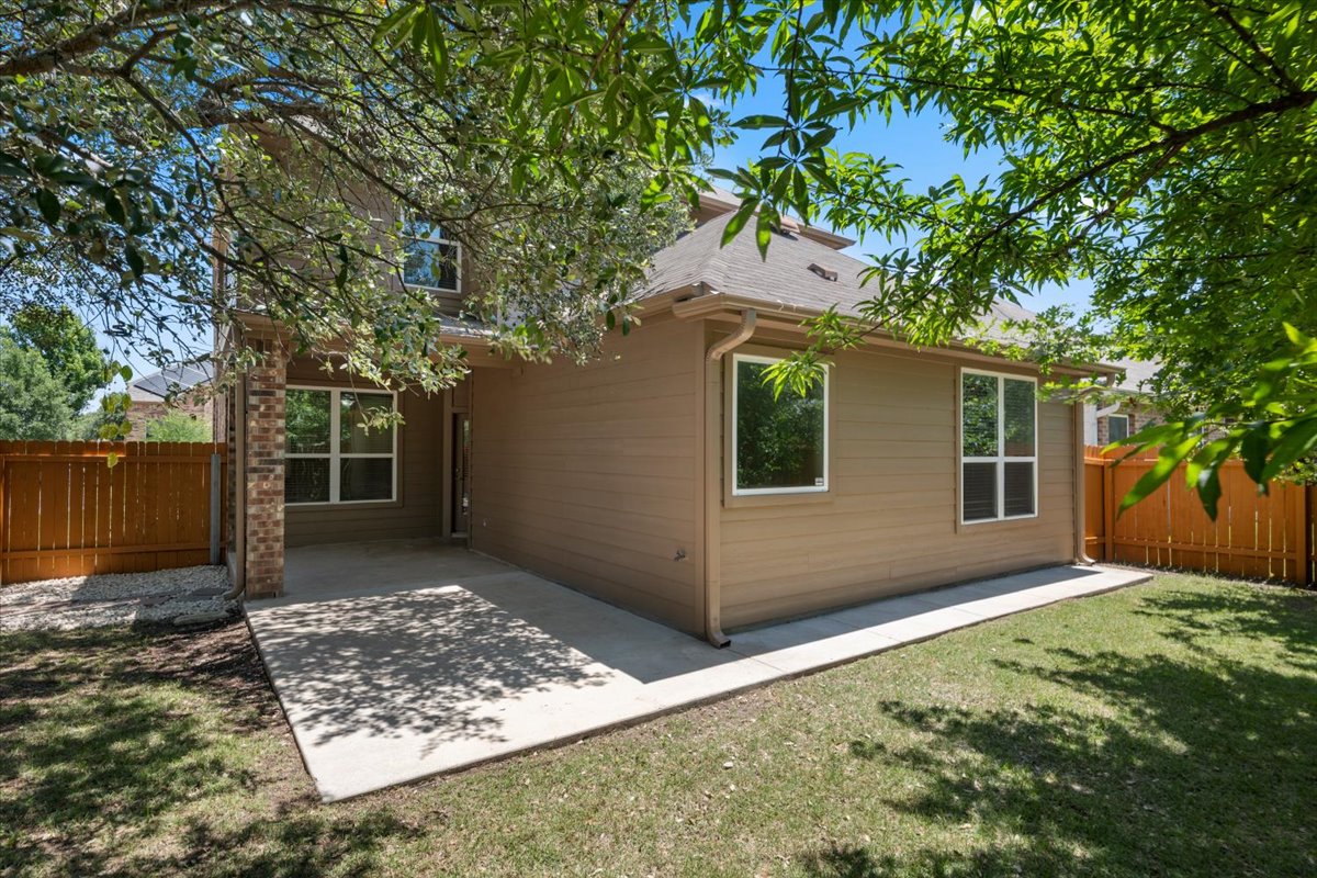 3451 Mayfield Ranch Boulevard, Unit 311 Round Rock, TX 78681 - Photo 36 of 40 Expansive backyard featuring a concrete patio, verdant lawn, and a privacy fence