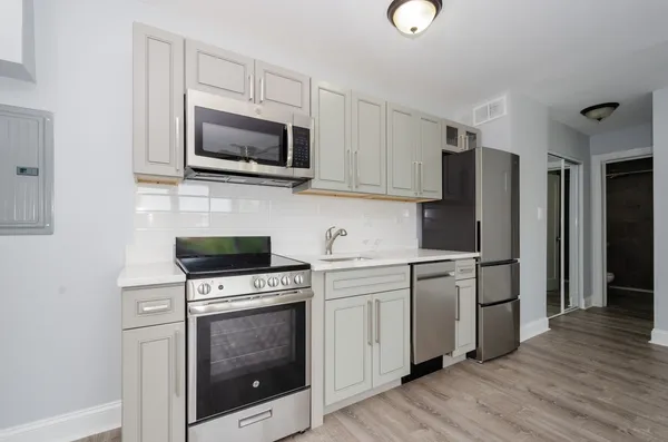 a kitchen with stainless steel appliances a stove a microwave and sink