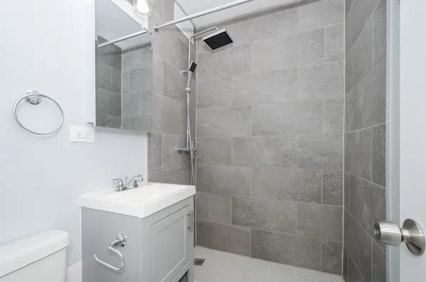 a bathroom with a sink a toilet and shower
