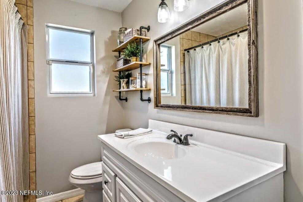 4233 Oak Lane St. Augustine, FL 32086 - Photo 26 of 40 a bathroom with a sink a toilet and a mirror