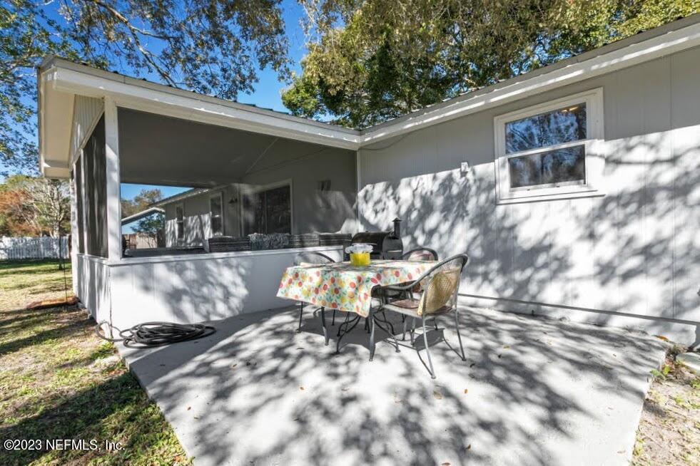 4233 Oak Lane St. Augustine, FL 32086 - Photo 33 of 40 a view of a patio with table and chairs with wooden floor and fence