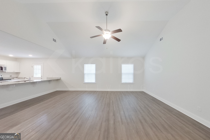 231 Western Red Cedar Drive Springfield, GA 31329 - Photo 5 of 26 a view of empty room with wooden floor and fan