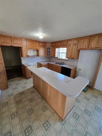an empty room with windows and fireplace