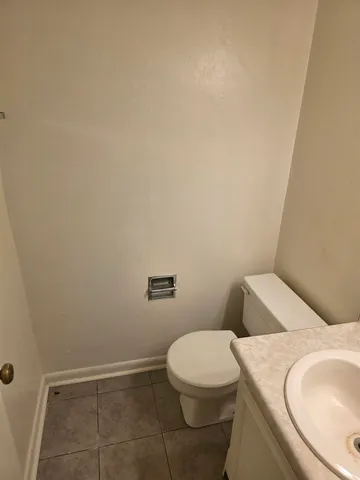 a white toilet sitting next to a white sink and vanity