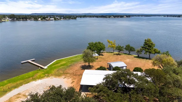 a view of a swimming pool with a yard and lawn chairs