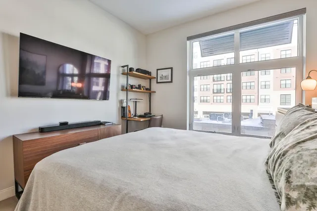 a bedroom with a bed and a large window