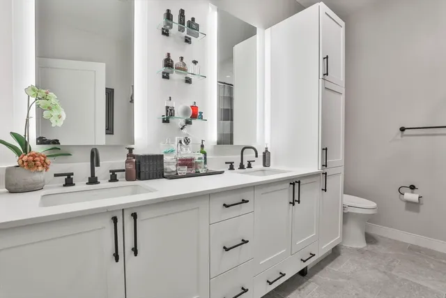 a bathroom with a granite countertop sink mirror and toilet