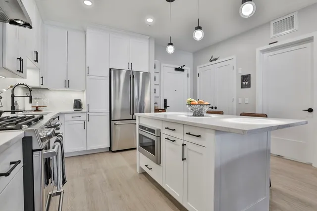 a kitchen with a sink stainless steel appliances and cabinets