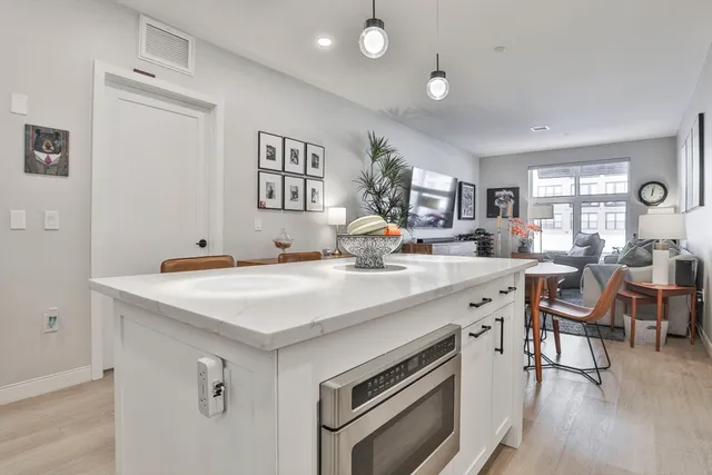 a view of kitchen island a sink wooden floor and living room