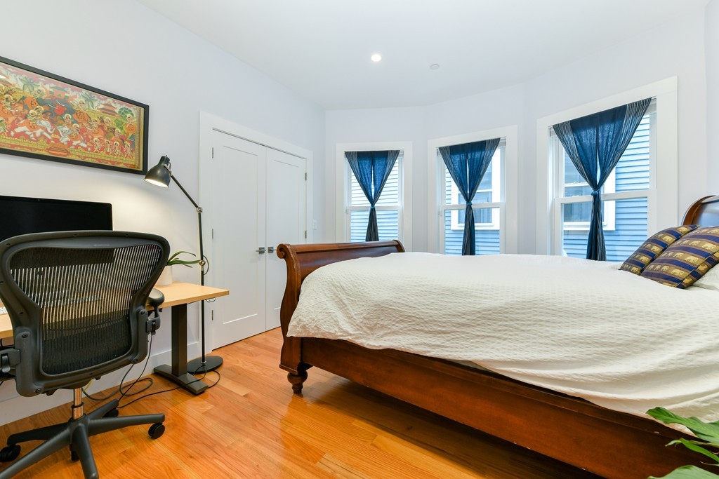 66 Wyman Street, Unit 1 Boston, MA 02130 - Photo 24 of 34 a bed sitting in a bedroom and tv