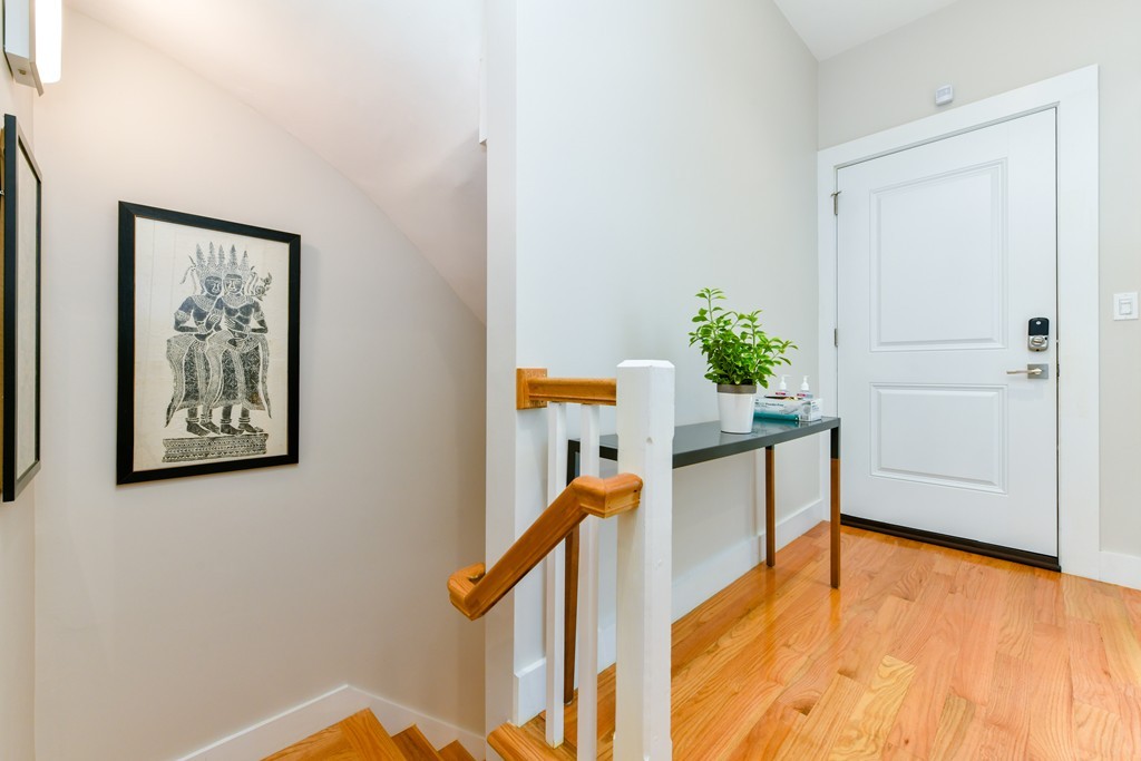 66 Wyman Street, Unit 1 Boston, MA 02130 - Photo 28 of 34 a view of a hallway with wooden floor and stairs