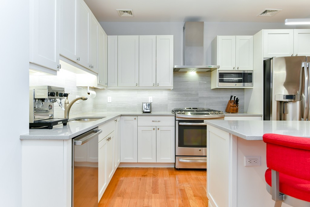 66 Wyman Street, Unit 1 Boston, MA 02130 - Photo 4 of 34 a kitchen with stainless steel appliances granite countertop a sink and cabinets
