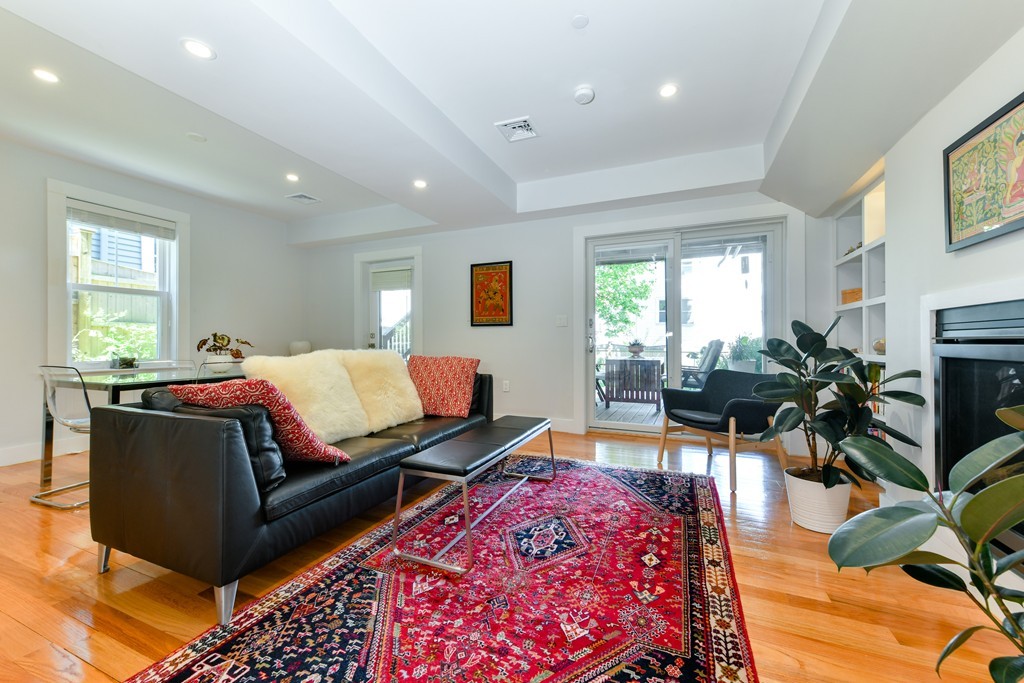 66 Wyman Street, Unit 1 Boston, MA 02130 - Photo 9 of 34 a spacious bedroom with a bed a couch and potted plant in it