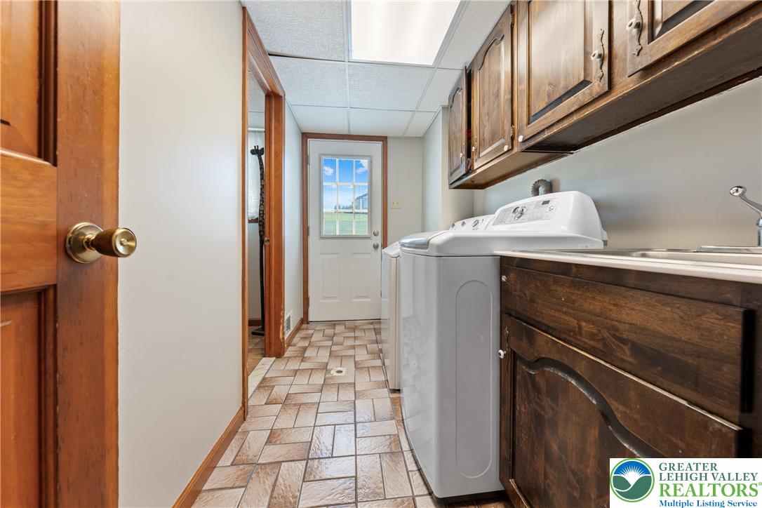 947 Tamenend Road Bath, PA 18014 - Photo 7 of 61 Functional laundry room offers a convenient sink, ample cabinetry, and direct exterior access.