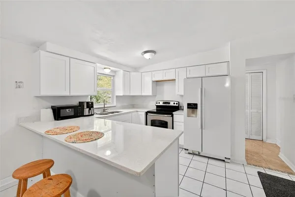 a kitchen with stainless steel appliances a refrigerator sink and white cabinets