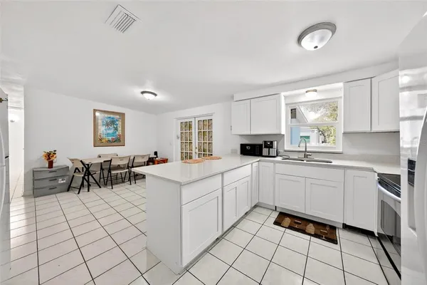a kitchen with white cabinets a sink and appliances
