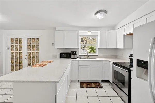 a kitchen with a stove a sink a microwave and cabinets