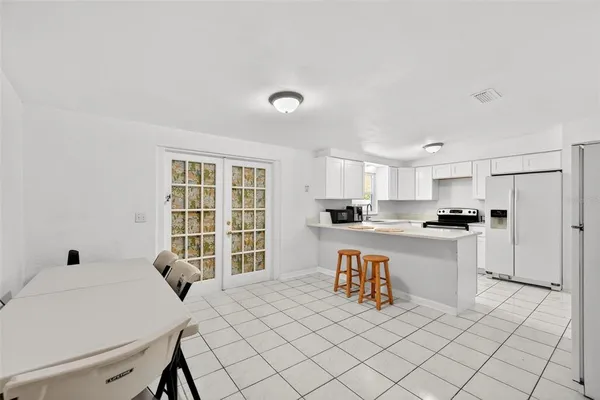 a living room with stainless steel appliances kitchen island granite countertop a sink and cabinets