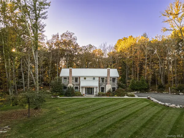 a view of a big house with a big yard and large trees