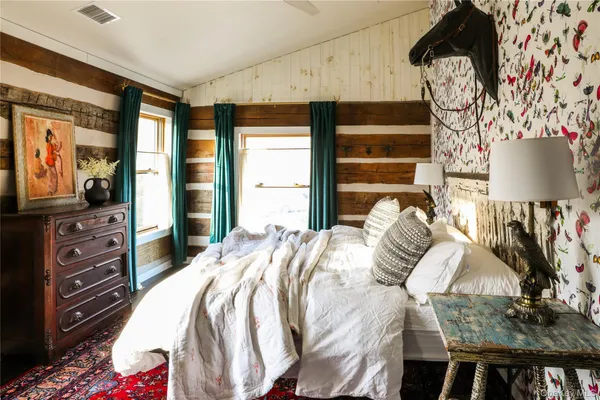 a bedroom with a bed and dresser with mirror
