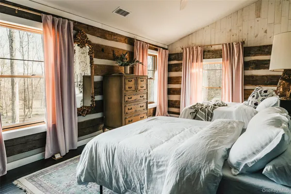 a bedroom with a bed a dresser and a large mirror