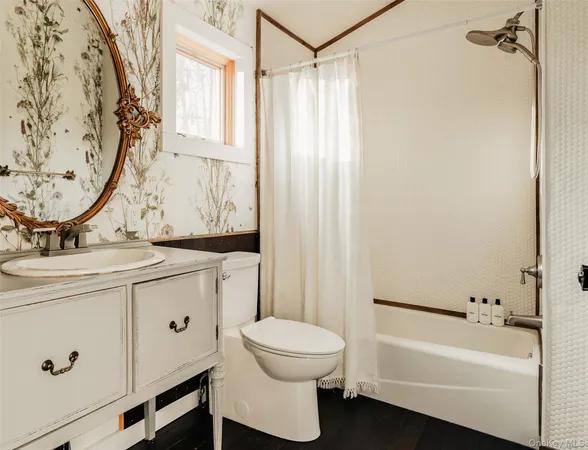 a bathroom with a granite countertop bathtub shower sink vanity and toilet