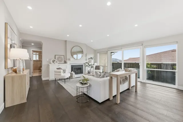 a living room with furniture a fireplace and a large mirror