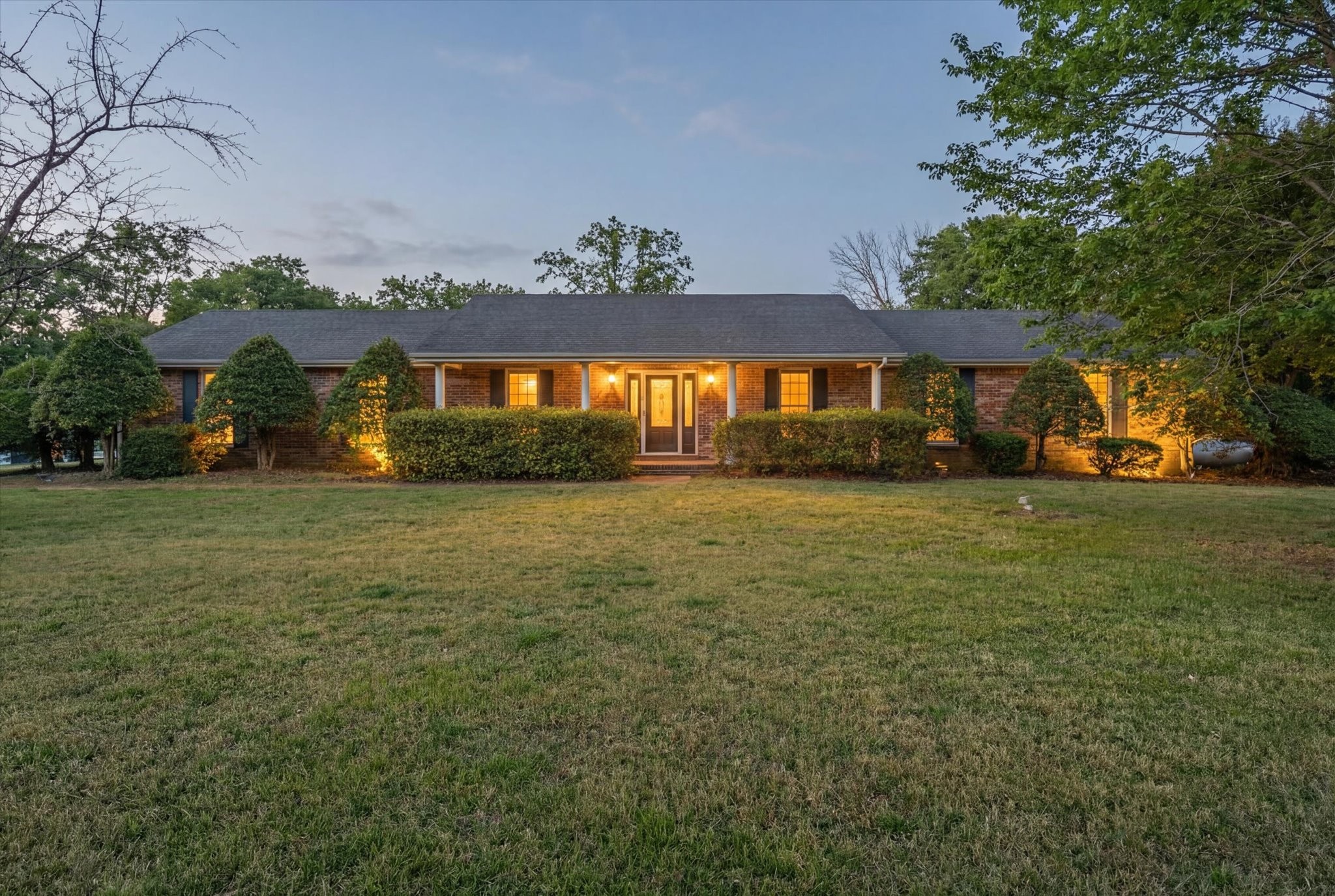 a front view of house with yard and trees