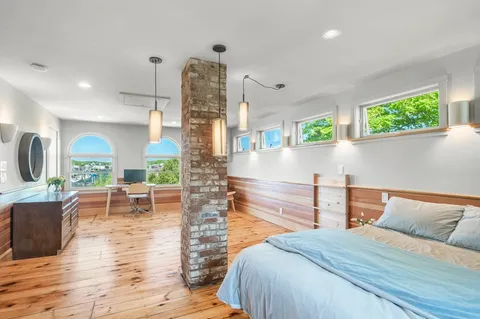 a bedroom with furniture and a large window