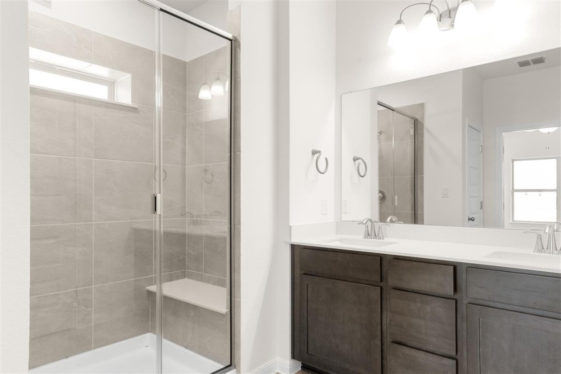 709 Paddock Lane Georgetown, TX 78626 - Photo 27 of 35 a bathroom with a shower sink and mirror