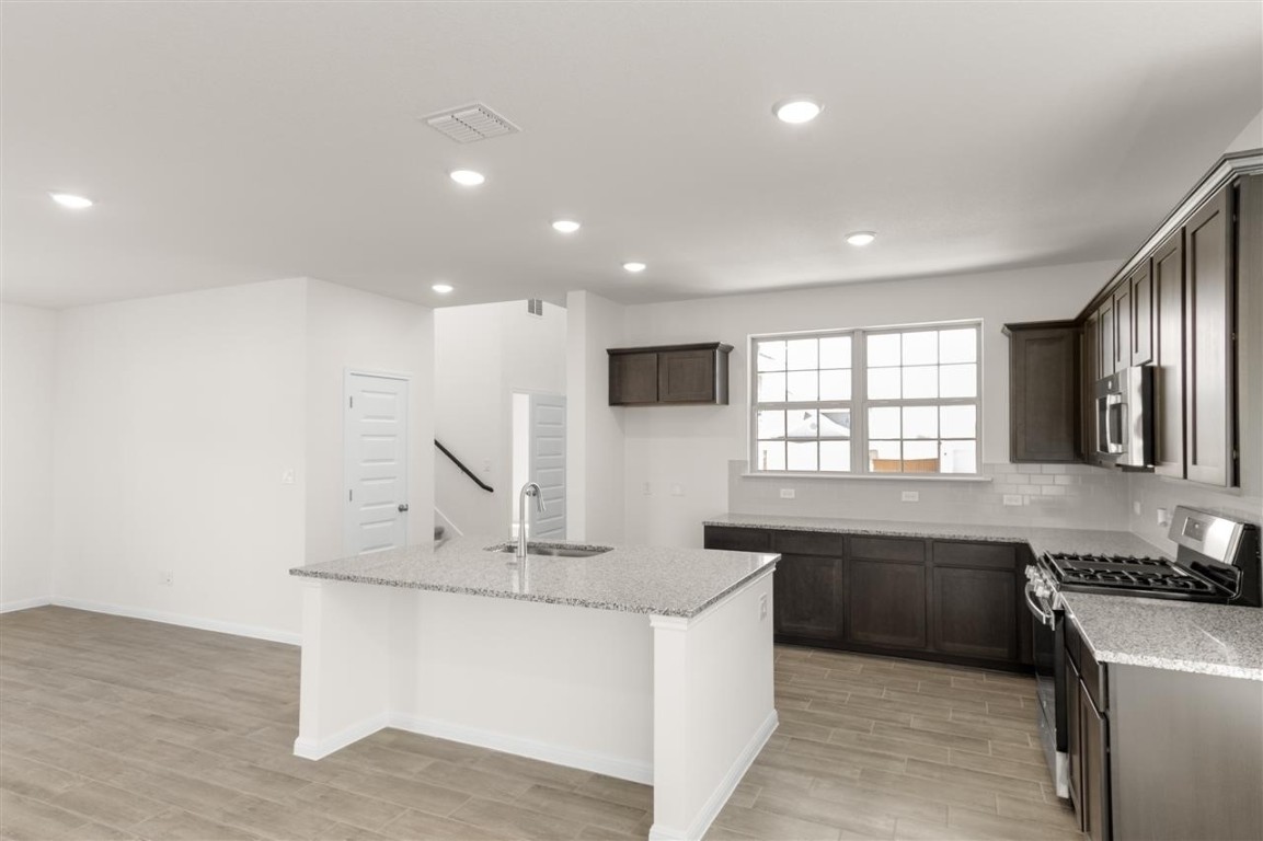 709 Paddock Lane Georgetown, TX 78626 - Photo 6 of 35 a kitchen with stainless steel appliances granite countertop a sink stove and refrigerator