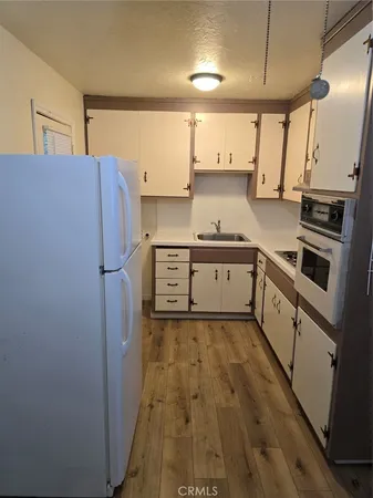 a kitchen with stainless steel appliances a sink cabinets and wooden floor